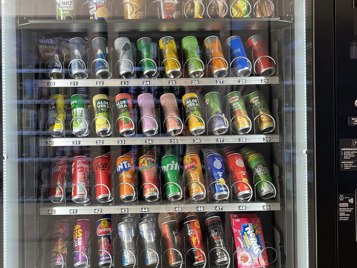 Blick in den Automaten: Getränkedosen, Snacks und Instant-Nudeln in nummerierten Fächern