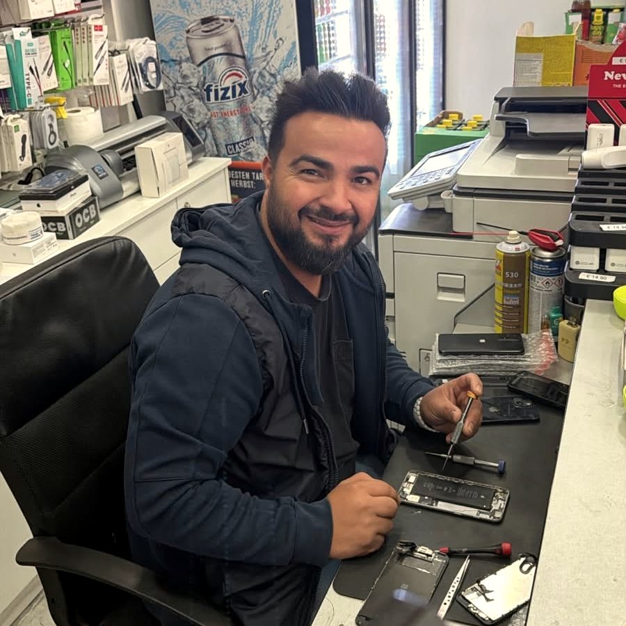 Ramazan Akpinar repariert ein Gerät an der Werkbank im Geschäft